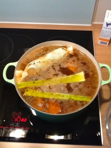 Roasted bones, vegetables, and herbs starting to simmer.